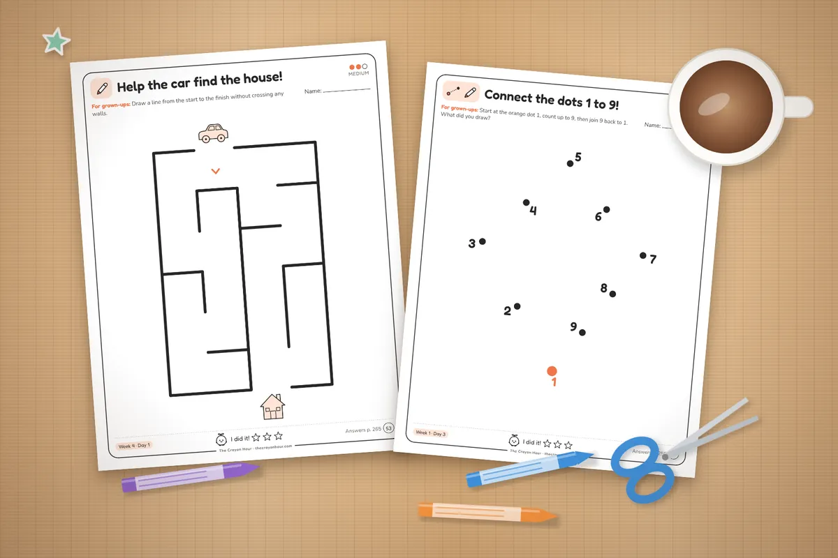 Printed maze and connect-the-dots pages on a table with a mug, scissors and crayons